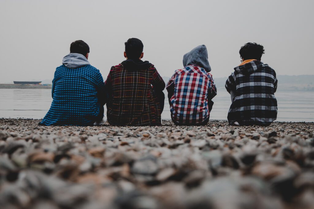 Four young people sat on the coast